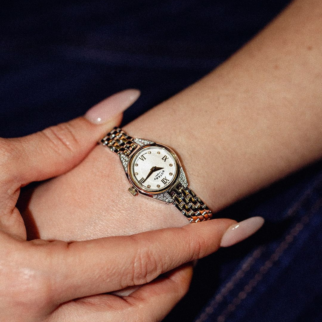 Rotary small ladies watch with crystal and diamond set case and dial. The watch is being worn by a woman with black clothing