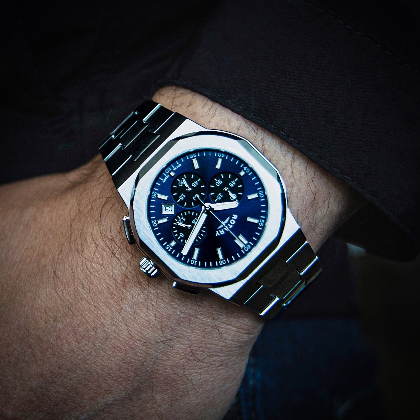 Rotary mens watch octagonal watch with a blue dial being worn by a man with a black shirt